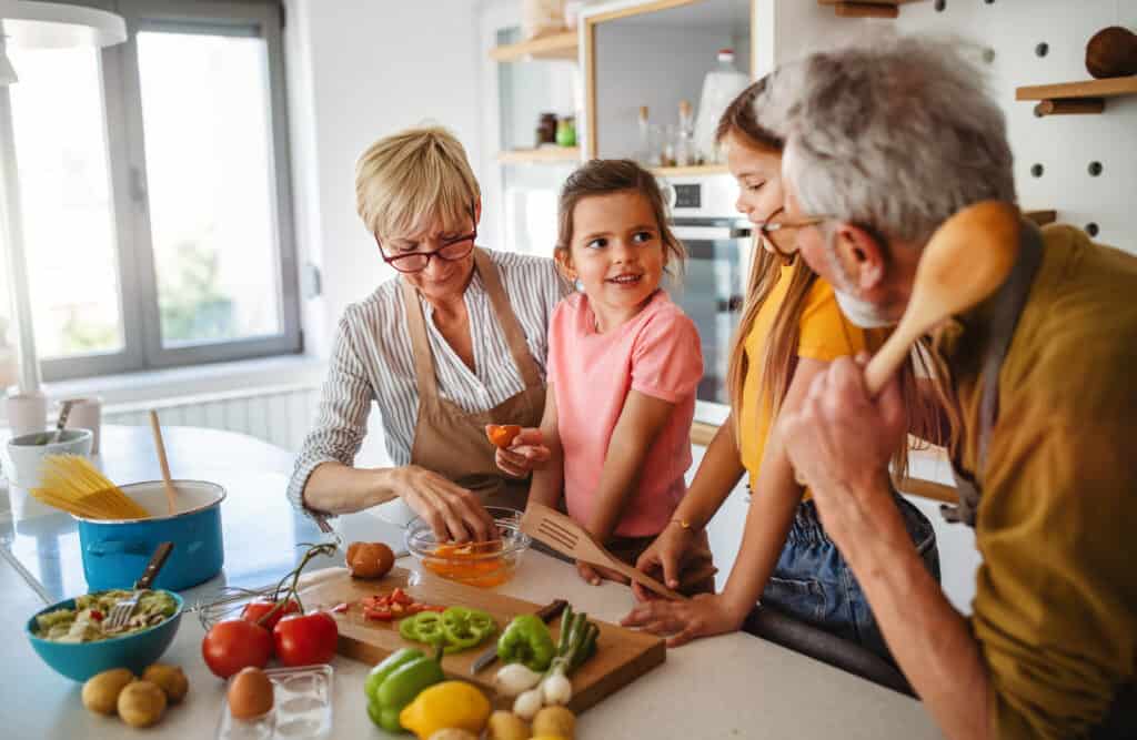 Grands parents qui cuisinent avec leurs petits enfants